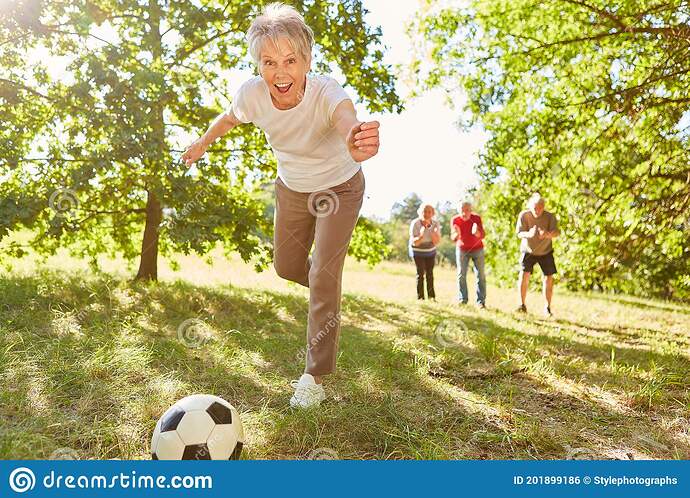 anciana-vital-que-juega-al-fútbol-con-sus-amigos-en-el-parque-verano-201899186