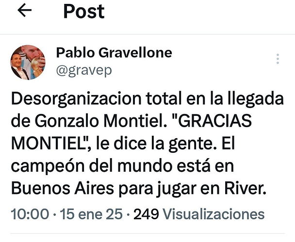 La imagen muestra un hermoso paisaje natural con un lago tranquilo y un cielo azul con nubes blancas, rodeado de árboles y montañas lejanas, con un <tag> en el primer plano que parece ser un banco o un lugar de descanso. (Subtitulado por IA)