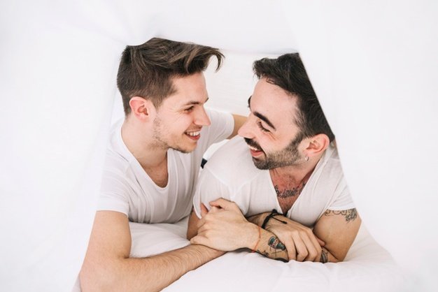 conteudo-casal-gay-posando-brincando-sob-cobertor_23-2147743605